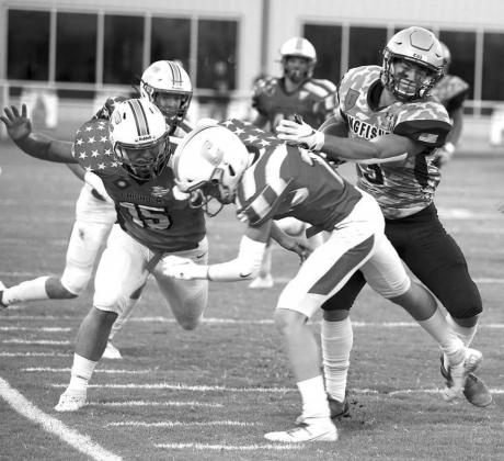 KINGFISHER RUNNING BACK Cade Stephenson (far right) tosses Chisholm’s Nick Deterding out of his path en route to a 55-yard touchdown run during last week’s game. Stephenson scored four Tds in the KHS win. [Photo by KHS Photography/www.khsphotography.smugmug.com]
