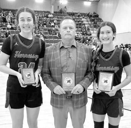 HENNESSEY’S Emma Copeland (right) was the MVP and Clare Munroe (left) joined her on the all-tournament team at Mooreland. They’re joined by their coach Brian Richardson after claiming the championship. [Photo provided]
