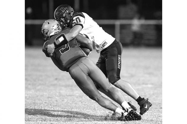 PERKINS JUNIOR Conner Williams (50) lays a hit on Kingfisher quarterback Cade Stephenson during Thursday night’s 34-13 win by the Demons. [Photo by Russell Stitt/www.stitt.smugmug.com Article Image Alt Text
