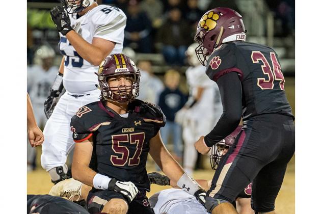 CASHION’S RYAN BAKER (57) and Jacob Farrow (34) begin to celebrate after sacking Min-co quarterback Cavin Russell along with their teammate Caden Harrell (9). [Photo by Brad Stone/www.bestone.shootproof.com Article Image Alt Text