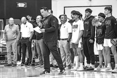 DOVER BOYS coach Jared Reese reads a message during a ceremony Tuesday at UCO outlining all the people who helped save the life of Randy Vitales (black sweatshirt) after the DHS sophomore collapsed during a a game. Dover honored all of those who offered h