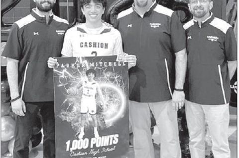 CASHION SENIOR guard Parker Mitchell was recognized prior to a game last week for surpasing 1,000 career points earlier this season. He’s pictured with Cashion coaches, from left, Brady Johnson, John Hardaway and Chad Tichenor. [Photo provided]