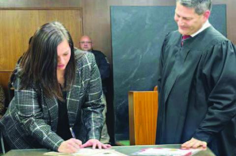 the signatures of (clockwise from top left) new District 2 County Commissioner Mike Sparks, Court Clerk Lauren Stroh, Sheriff Aaron Pitts and County Clerk Emily Lee. The ceremony took place inside the courtroom at the Kingfisher County Courthouse. Each ne