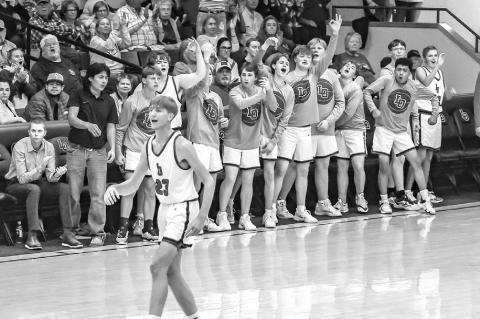LOMEGA’S Chase Burton (23) looks on as Raiders react to a made 3-pointer during their victory in last Friday’s season opener against Dover. [Photo by Chris Simon/www.simon-sports-photos.smugmug.com]